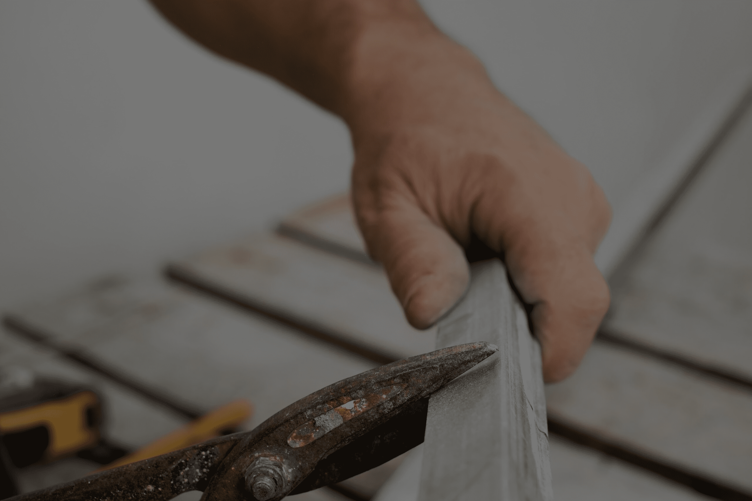 Hand eines Handwerkers hält eine Zange, um Holz präzise zu bearbeiten.